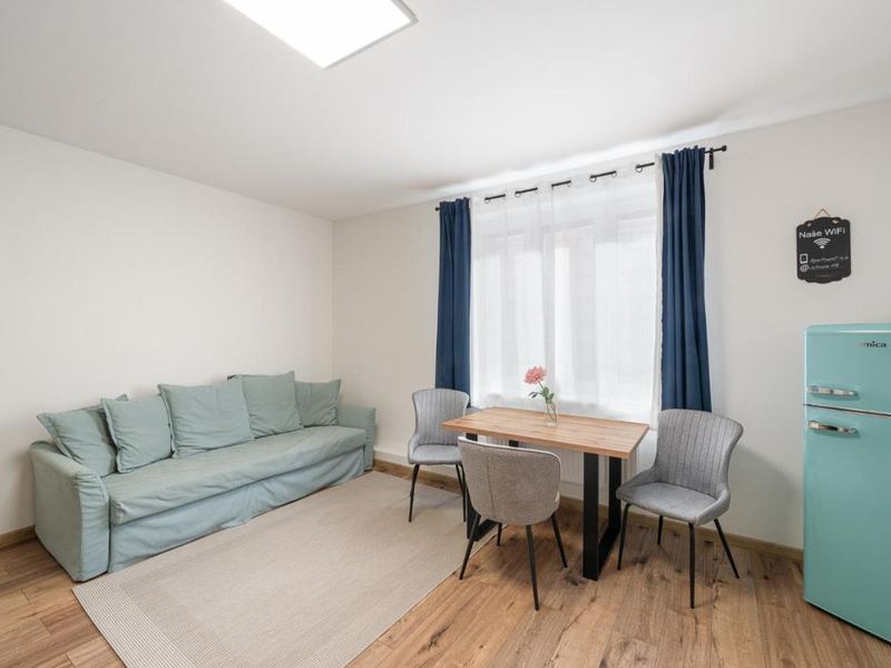 Living area with sofa, dining table and pastel fridge